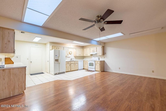 kitchen featuring ceiling fan, sink, light hardwood / wood-style flooring, a textured ceiling, and white appliances