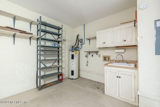 basement with a textured ceiling, electric water heater, and sink