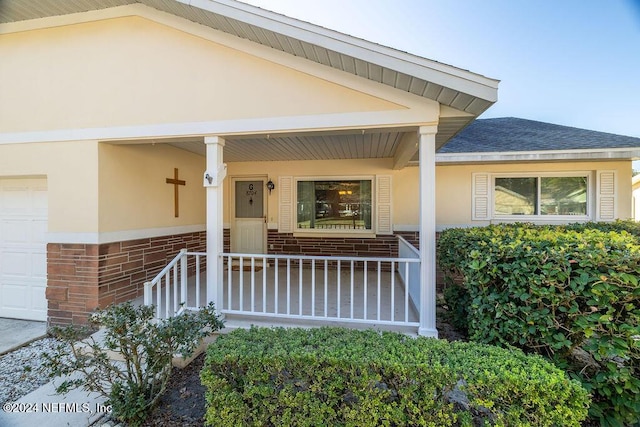 entrance to property featuring a porch and a garage