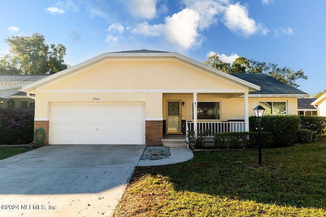 view of front of house featuring a porch, a garage, and a front lawn