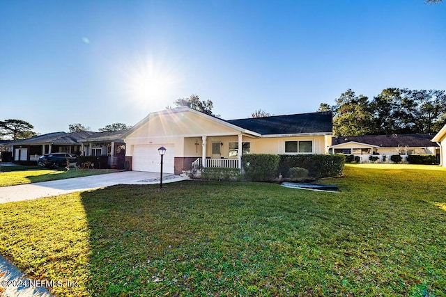 ranch-style home with covered porch, a garage, and a front yard