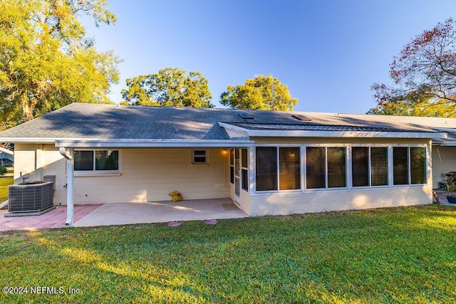 back of property with a lawn, cooling unit, and a patio