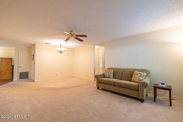 living room with ceiling fan, carpet floors, and a textured ceiling