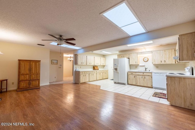 kitchen featuring white appliances, sink, light hardwood / wood-style flooring, ceiling fan, and a textured ceiling