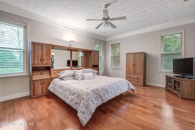 bedroom featuring ceiling fan, light hardwood / wood-style flooring, and ornamental molding