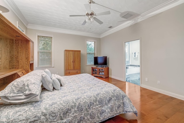 bedroom with light wood-type flooring, ensuite bathroom, ceiling fan, and crown molding