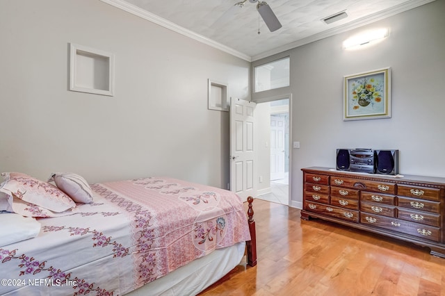 bedroom with light hardwood / wood-style floors, ceiling fan, and crown molding