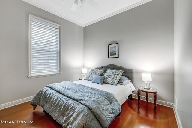 bedroom with hardwood / wood-style flooring, ceiling fan, and crown molding