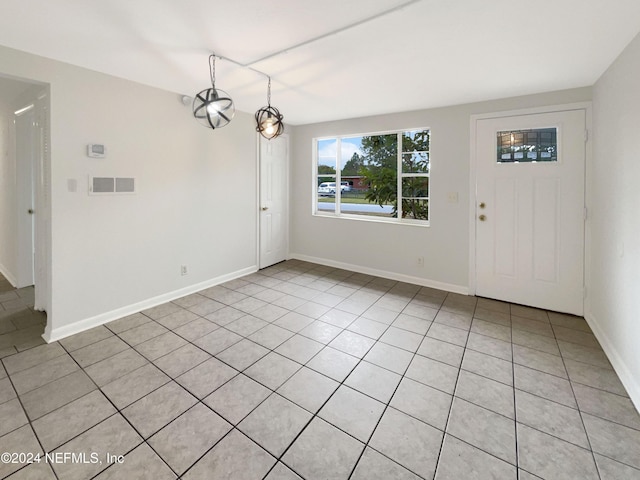 unfurnished dining area featuring light tile patterned floors and an inviting chandelier