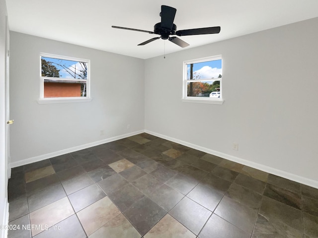 tiled spare room with ceiling fan