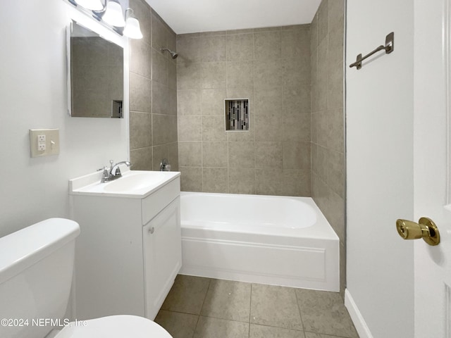 full bathroom with toilet, tile patterned flooring, vanity, and tiled shower / bath