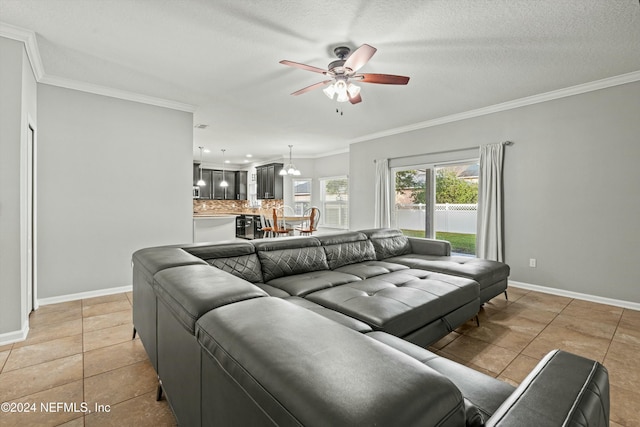 living room featuring light tile patterned floors, a textured ceiling, ornamental molding, and ceiling fan