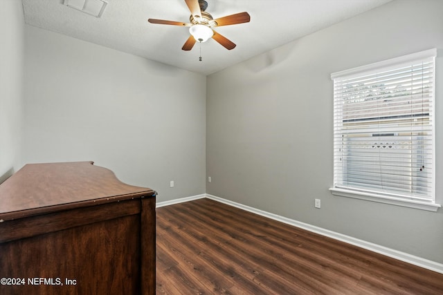 spare room with dark hardwood / wood-style flooring and ceiling fan