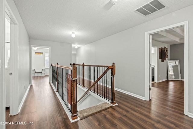 hall featuring dark hardwood / wood-style floors and a textured ceiling