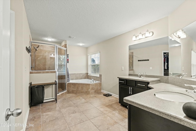 bathroom with vanity, plus walk in shower, tile patterned flooring, and a textured ceiling