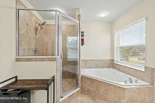 bathroom featuring tile patterned flooring, plus walk in shower, and a textured ceiling