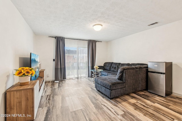 living room with a textured ceiling and hardwood / wood-style flooring