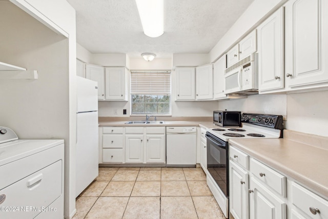 kitchen featuring sink, light tile patterned floors, washer / clothes dryer, white appliances, and white cabinets