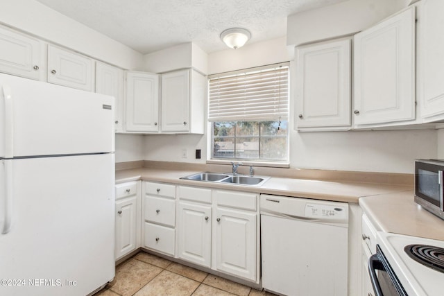 kitchen with white appliances, sink, light tile patterned floors, a textured ceiling, and white cabinetry