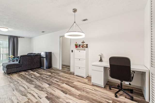 office space with light hardwood / wood-style floors and a textured ceiling