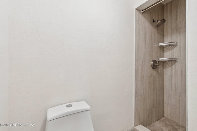 bathroom with toilet and tiled shower