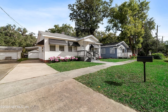 view of front of house featuring a front yard, an outbuilding, and a garage