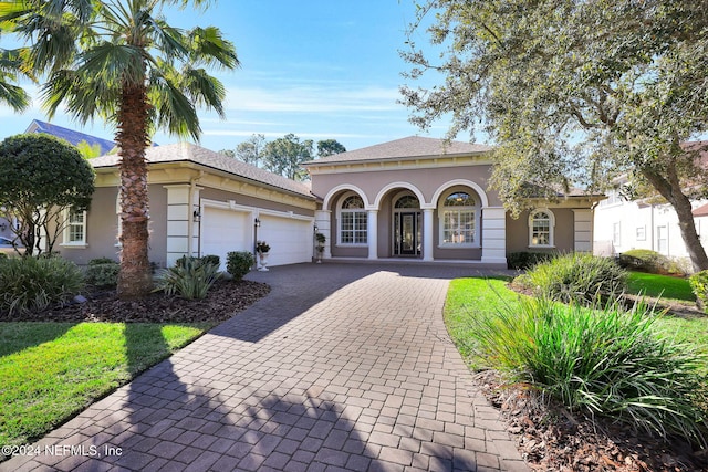 mediterranean / spanish-style home featuring a porch and a garage