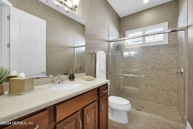 bathroom with tile patterned flooring, vanity, a shower with door, and toilet