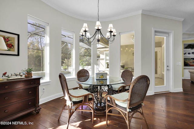 dining space with dark hardwood / wood-style floors, crown molding, and an inviting chandelier