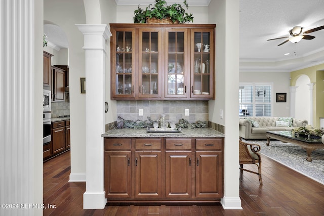 bar featuring dark hardwood / wood-style flooring, ornamental molding, a textured ceiling, and appliances with stainless steel finishes