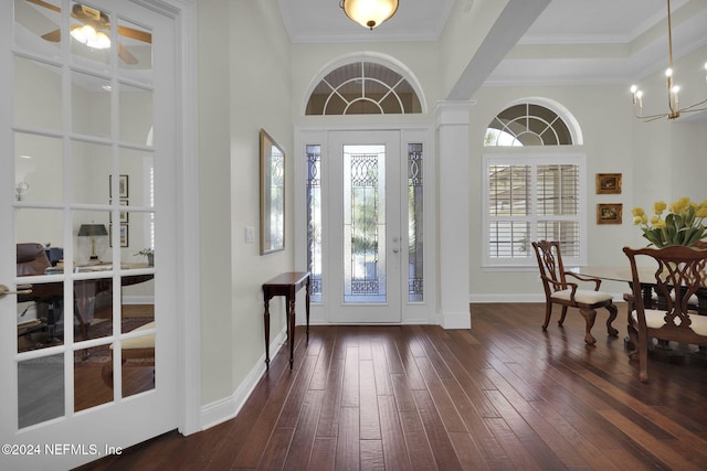 foyer featuring ceiling fan with notable chandelier, dark hardwood / wood-style flooring, ornamental molding, and a towering ceiling