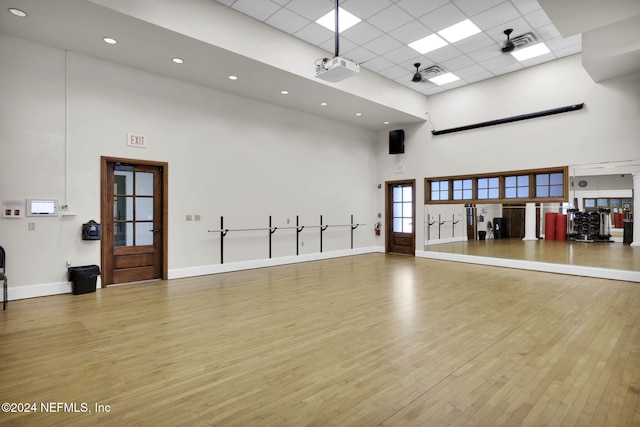 interior space featuring hardwood / wood-style floors, a towering ceiling, and a paneled ceiling