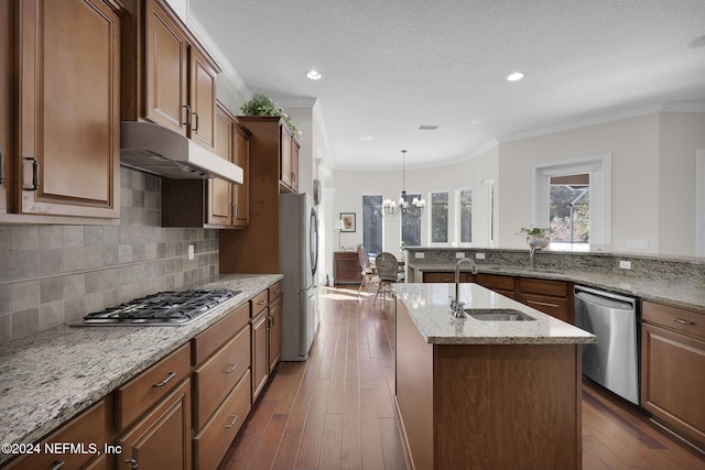 kitchen with a center island with sink, sink, dark hardwood / wood-style floors, light stone countertops, and stainless steel appliances