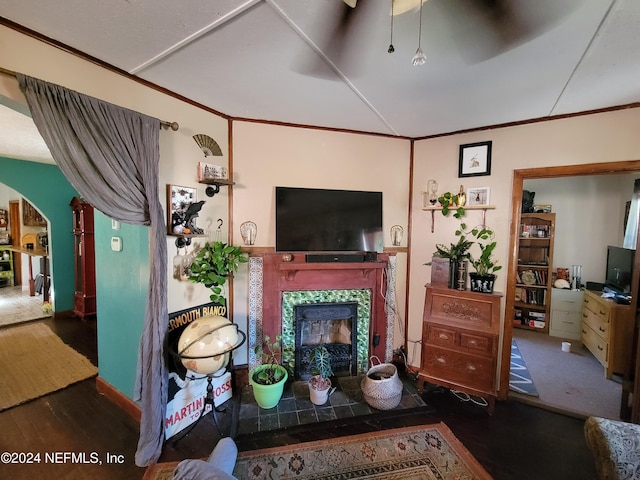 living room featuring crown molding, dark hardwood / wood-style flooring, and a fireplace