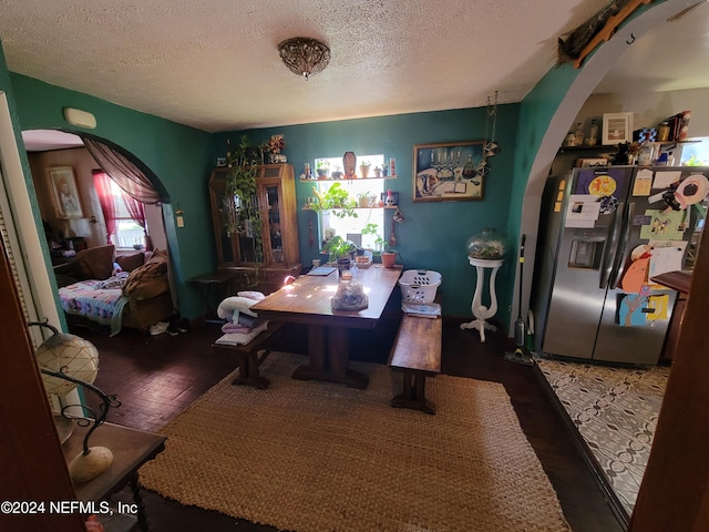 dining room featuring dark hardwood / wood-style floors and a textured ceiling