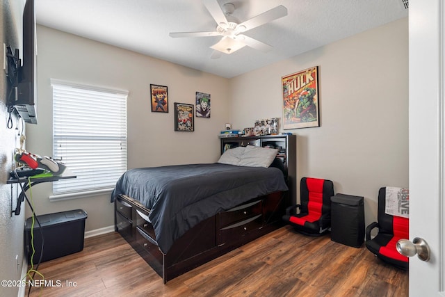 bedroom with hardwood / wood-style flooring, ceiling fan, and multiple windows