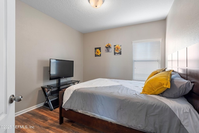 bedroom with a textured ceiling and dark wood-type flooring