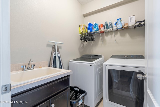 laundry room featuring cabinets, independent washer and dryer, and sink