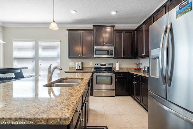 kitchen featuring pendant lighting, sink, light tile patterned floors, appliances with stainless steel finishes, and light stone counters