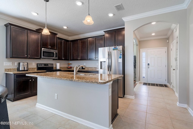 kitchen with decorative light fixtures, light tile patterned floors, a kitchen island with sink, and appliances with stainless steel finishes