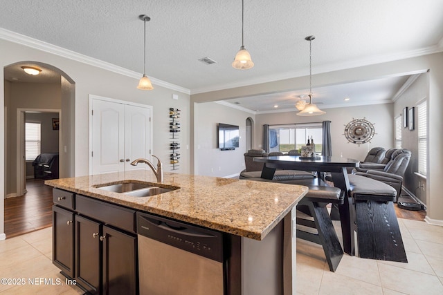 kitchen with a kitchen island with sink, dishwasher, light tile patterned flooring, and sink