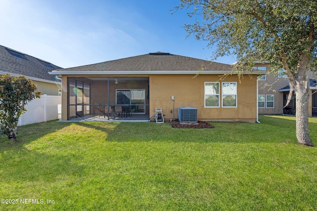 back of property with a sunroom, cooling unit, ceiling fan, a yard, and a patio area