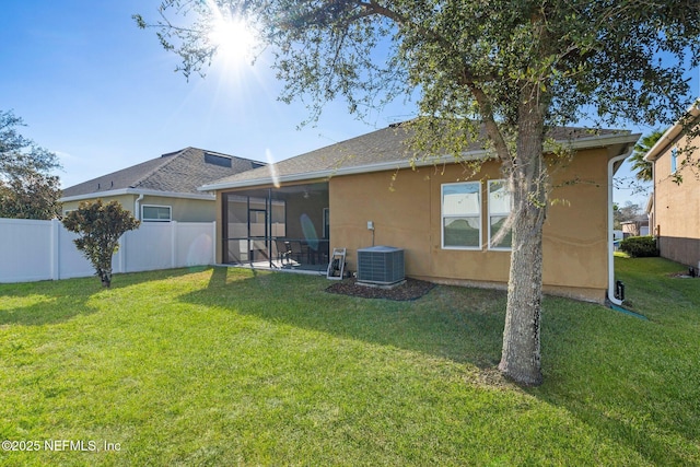 back of house featuring a sunroom, a yard, and cooling unit