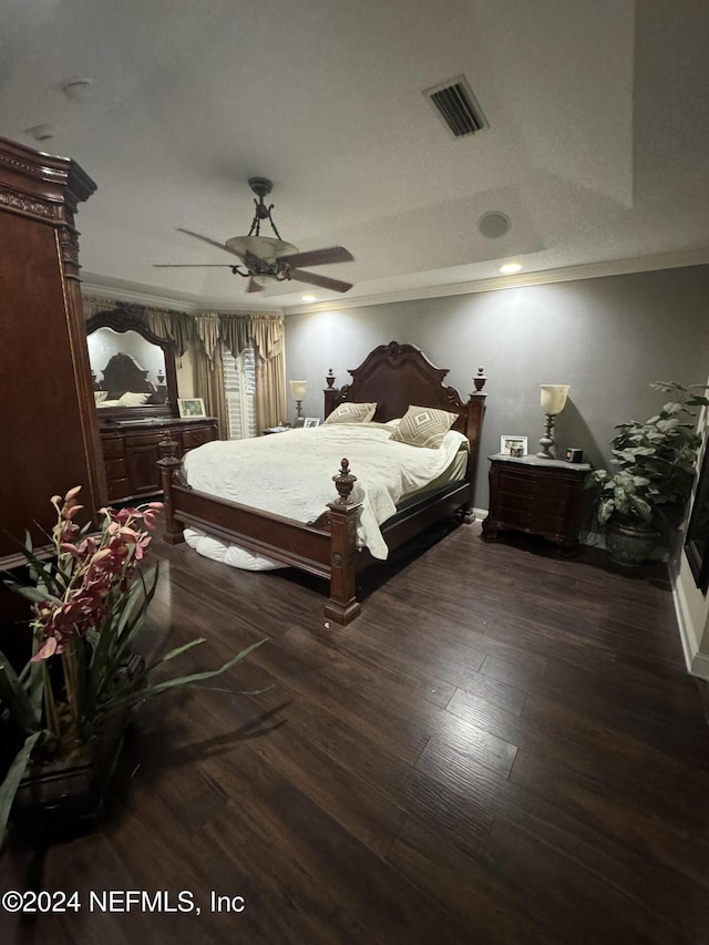 bedroom featuring dark hardwood / wood-style flooring, ceiling fan, and crown molding