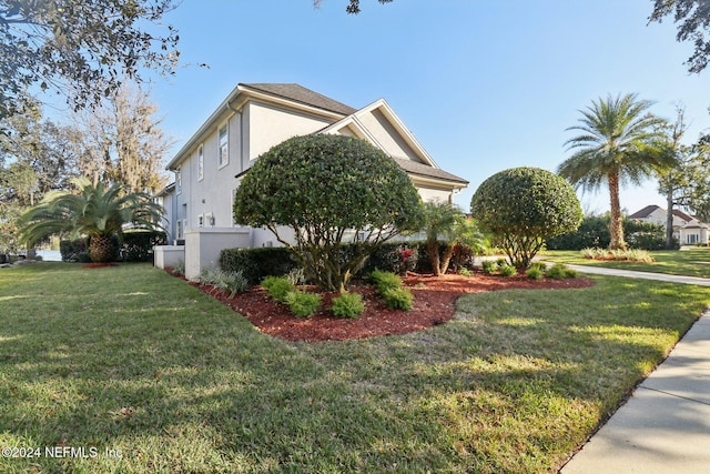 view of side of home with a yard