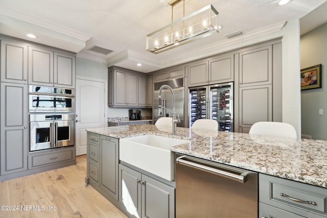 kitchen with gray cabinetry, stainless steel appliances, wine cooler, decorative light fixtures, and ornamental molding