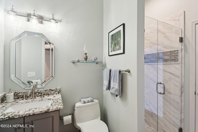 bathroom featuring vanity, toilet, and a shower with shower door