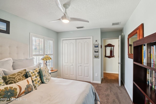 carpeted bedroom featuring ceiling fan, a textured ceiling, and a closet