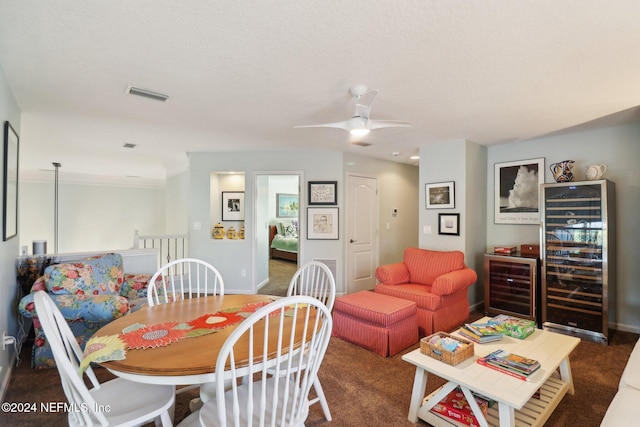 dining space with dark colored carpet, ceiling fan, and wine cooler