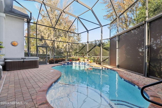 view of swimming pool featuring glass enclosure and a patio